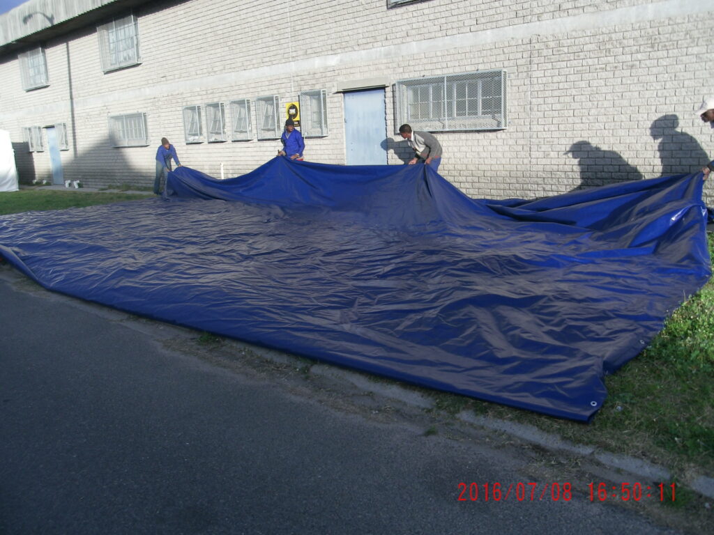 Blue tarpaulin being folded up